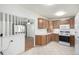 Functional kitchen with white appliances, light wood cabinets, and bright tile flooring, perfect for easy meal preparation at 1661 E 86Th Pl, Denver, CO 80229