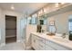 A bright bathroom with a double sink vanity, glass shower with marble and a walk-in closet at 9769 E 62Nd Dr, Denver, CO 80238