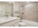 Modern bathroom with a shower over tub, white countertop, and light wood-look tile at 9769 E 62Nd Dr, Denver, CO 80238