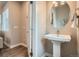 Clean, bright bathroom with a pedestal sink, round mirror, and modern fixtures, perfect for guests at 9769 E 62Nd Dr, Denver, CO 80238