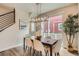 Cozy dining area with modern lighting, seating for six, and sliding doors to the outdoor patio at 9769 E 62Nd Dr, Denver, CO 80238