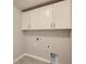 A well-equipped laundry room with upper cabinets and utility hookups at 9769 E 62Nd Dr, Denver, CO 80238