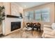 Elegant living room featuring a fireplace, stylish decor, and large windows that provide ample light at 9769 E 62Nd Dr, Denver, CO 80238