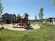 Community playground with a slide, climbing structure, and seating areas surrounded by lush landscaping at 2668 W 68Th Ave, Denver, CO 80221