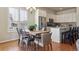 Charming dining area with a rustic wooden table, modern chairs, and a view of the kitchen with stainless steel appliances at 22965 E Bailey Cir, Aurora, CO 80016