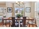 Charming dining room with a wooden table, upholstered chairs, and large window overlooking the backyard at 22965 E Bailey Cir, Aurora, CO 80016