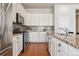 Well-lit kitchen with stainless steel appliances, granite countertops, tile backsplash, and sleek white cabinets at 22965 E Bailey Cir, Aurora, CO 80016