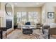 Bright living room features a fireplace, two large windows, a white sofa, and modern decor at 22965 E Bailey Cir, Aurora, CO 80016