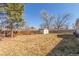 Spacious backyard featuring a fenced perimeter and a storage shed among mature trees at 3541 E 118Th Ave, Thornton, CO 80233