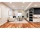 Open basement living area with hardwood floors, neutral walls, and built-in shelving at 8806 E 35Th Ave, Denver, CO 80238