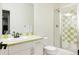 Bathroom with white vanity, green tile, and glass-enclosed shower at 8806 E 35Th Ave, Denver, CO 80238