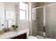 Bathroom features a vanity with sink, toilet, and glass-enclosed shower with tile surround and shower head at 8806 E 35Th Ave, Denver, CO 80238