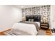 Modern bedroom with floral wallpaper accent wall and upholstered headboard at 8806 E 35Th Ave, Denver, CO 80238