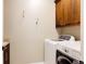 Laundry room with wood cabinets and modern washer and dryer units at 8806 E 35Th Ave, Denver, CO 80238