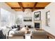 Bright living room featuring a fireplace, wood ceiling beams, and large windows for a welcoming atmosphere at 8806 E 35Th Ave, Denver, CO 80238