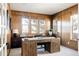 Well-lit home office with wood paneling, a large window offering bright light, and ample workspace at 8806 E 35Th Ave, Denver, CO 80238