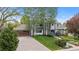 Inviting two-story home featuring a tile roof, lush lawn, and mature trees offering shade and curb appeal at 172 S Forest St, Denver, CO 80246