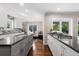 Bright kitchen featuring white cabinets, gray island with granite countertops and stainless steel appliances at 172 S Forest St, Denver, CO 80246