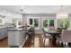 Modern kitchen with stainless steel appliances, a granite island, and an adjacent dining area with natural light at 172 S Forest St, Denver, CO 80246