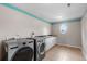 Well-equipped laundry room with modern washer, dryer, and oval window at 172 S Forest St, Denver, CO 80246