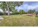 Large backyard with green grass, mature trees, and a trampoline, perfect for outdoor enjoyment and relaxation at 8471 Rainbow Ave, Denver, CO 80229