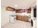 Basement kitchenette area with cabinets, sink, stove, and washer/dryer at 8471 Rainbow Ave, Denver, CO 80229
