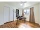 Bright bedroom featuring a desk area, hardwood floors, and closet with sliding doors at 8471 Rainbow Ave, Denver, CO 80229