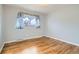 Cozy bedroom with hardwood floors, neutral decor, and a large window with natural light at 8471 Rainbow Ave, Denver, CO 80229