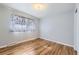 Simple bedroom with hardwood floors and a window covered with curtains at 8471 Rainbow Ave, Denver, CO 80229