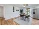 Dining area featuring hardwood floors, modern light fixture, and stainless steel refrigerator at 8471 Rainbow Ave, Denver, CO 80229