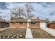 Charming brick home features a well-maintained lawn and a paved walkway at 8471 Rainbow Ave, Denver, CO 80229