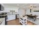 Open kitchen featuring white cabinetry, stainless steel appliances, and dining area at 8471 Rainbow Ave, Denver, CO 80229