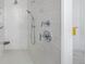 Shower with a handheld and fixed shower head, white tiled walls, corner seat, and chrome fixtures at 13633 Mariposa St, Broomfield, CO 80023