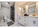 The bathroom offers a double vanity, sleek fixtures, and a modern walk-in shower with black framing for a spa-like feel at 8340 W 70Th Ave, Arvada, CO 80004