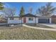 Charming updated home featuring a bright red door, fresh white paint, and an attached garage at 8340 W 70Th Ave, Arvada, CO 80004
