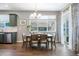 Bright dining room with stylish chandelier, large window, and door to the patio, adjacent to the kitchen at 27130 E Maple Ave, Aurora, CO 80018