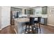 Well-lit kitchen boasts a center island, stainless appliances, and green cabinets for a modern aesthetic at 27130 E Maple Ave, Aurora, CO 80018