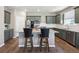Modern kitchen featuring a kitchen island with chairs, stainless steel appliances, and white subway tile backsplash at 27130 E Maple Ave, Aurora, CO 80018