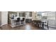 Open-concept kitchen and dining area with island seating, stainless steel appliances, and a modern dining table at 27130 E Maple Ave, Aurora, CO 80018