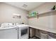 Functional laundry room with modern washer and dryer, shelving and dark tile flooring at 27130 E Maple Ave, Aurora, CO 80018