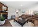 Bright living room with a brown leather sectional, wood accent fireplace, and neutral color palette at 27130 E Maple Ave, Aurora, CO 80018