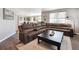 Inviting living room with a spacious brown sectional sofa and an open view to the kitchen at 27130 E Maple Ave, Aurora, CO 80018