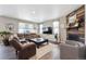 Cozy living room featuring a brown leather sectional, fireplace with wood accent wall, and neutral decor at 27130 E Maple Ave, Aurora, CO 80018