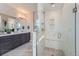 Bathroom view with a marble style glass-enclosed shower, double vanity with gray cabinets and a large mirror at 307 W Charles St, Superior, CO 80027