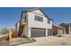 Home exterior with two-car garage, a secondary staircase and patio, and neutral siding with dark trim at 307 W Charles St, Superior, CO 80027