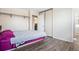 Cozy bedroom featuring wood flooring, a closet with sliding doors, and a doorway to the adjacent bathroom at 2644 S Norfolk St, Aurora, CO 80013