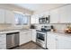 Bright kitchen with stainless steel appliances, white cabinets, laminate countertops, and a stainless steel sink at 2644 S Norfolk St, Aurora, CO 80013