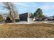 Exterior view of the home with gray siding and a large front yard at 7882 S Independence Way, Littleton, CO 80128