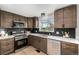 Updated kitchen featuring stainless steel appliances, granite countertops, and modern fixtures and wood flooring at 7882 S Independence Way, Littleton, CO 80128