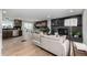 Open-concept living room featuring a modern fireplace, updated kitchen, and beautiful hardwood floors at 7882 S Independence Way, Littleton, CO 80128